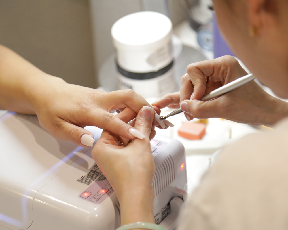salon marketing tips, foto van nagelstyliste aan het werk op lange nagels